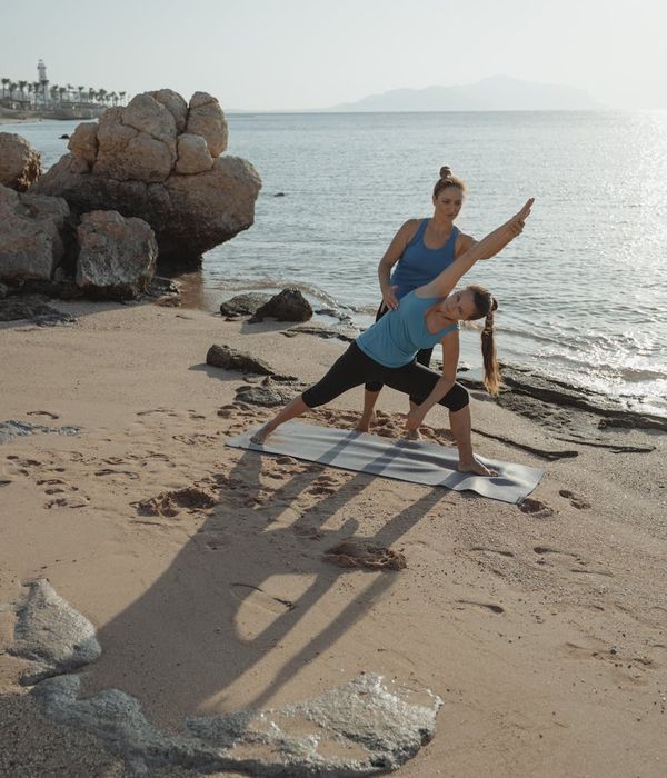 Woman holding a serene and balanced yoga pose outdoors during sunrise.